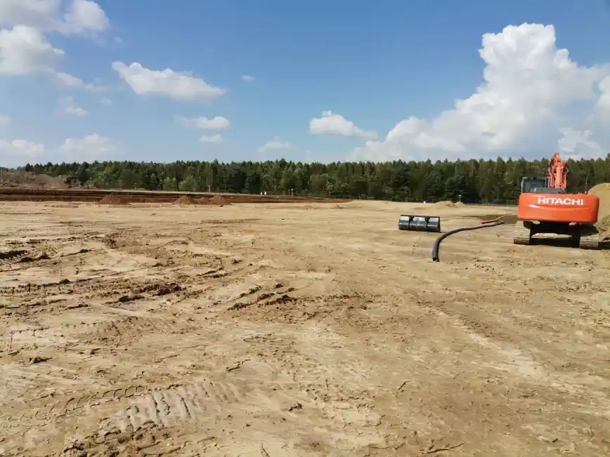 koparka wstępnie rozgarnia piach